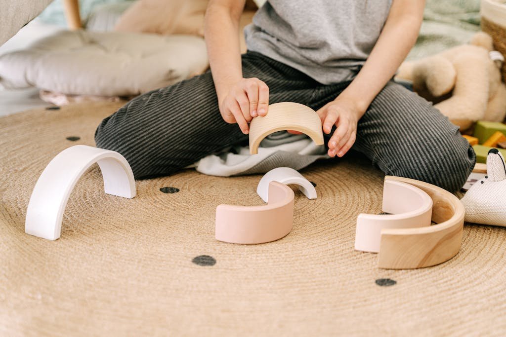 A child engaging in play with wooden arched blocks, enhancing motor skills and creativity.